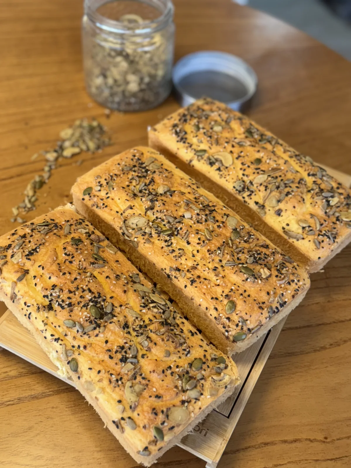Pães proteicos da confeitaria em formas individuais, com cobertura de granola e sementes